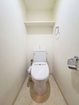 【トイレ】白を基調とした清潔感のあるトイレ。上部には棚があり、トイレットペーパーなどを収納できます。