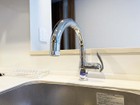 浄水機能と一体となったデザイン性の高いグースネック型の水栓／先端が伸びてシンク内の隅々までお掃除できます